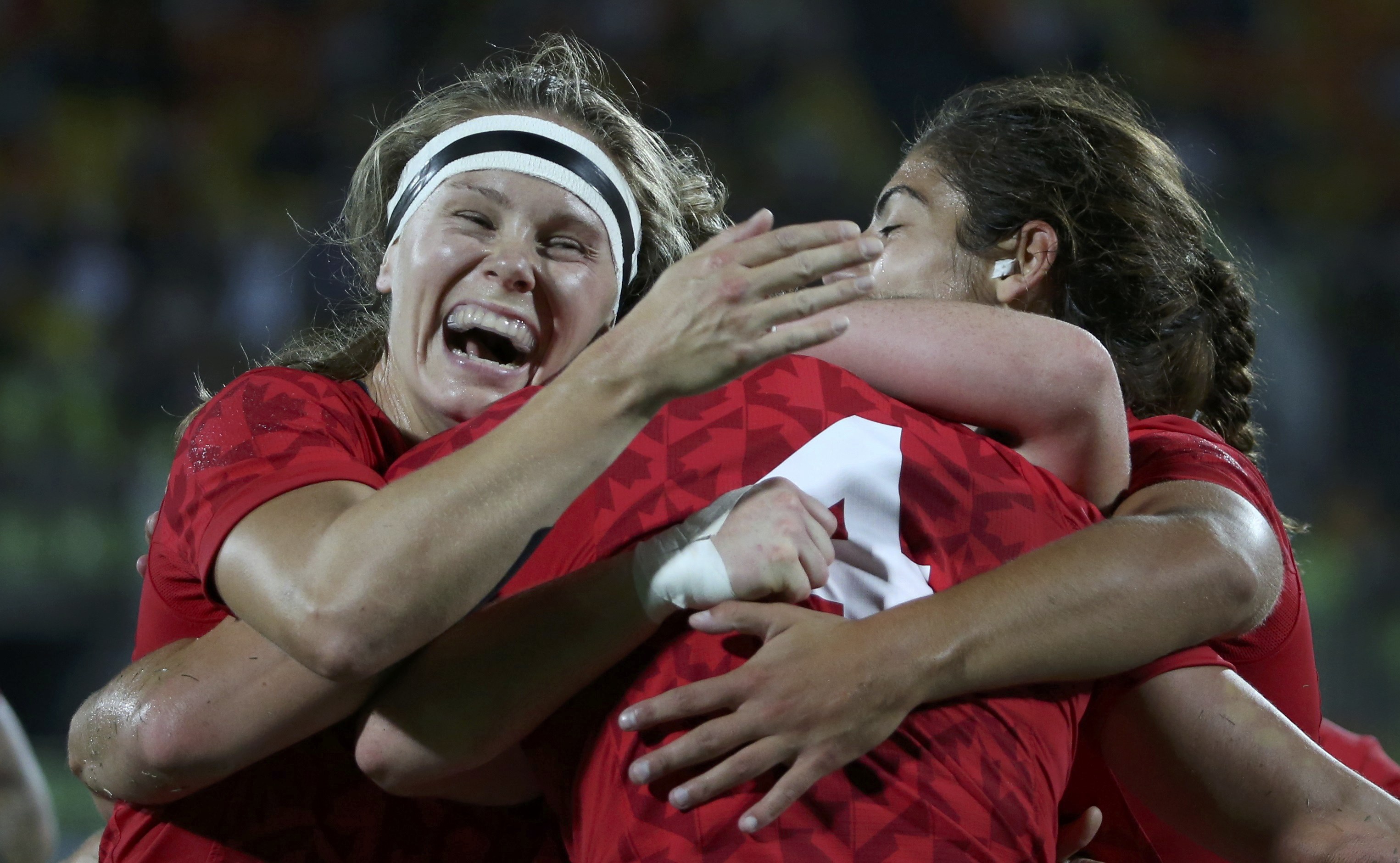 O Canad&aacute; j&aacute; compete no r&uacute;gbi masculino desde a Olimp&iacute;ada de 1924. Mas, para o time feminino, os Jogos Ol&iacute;mpicos de 2016 s&atilde;o os primeiros - mesmo que as jogadoras j&aacute; tenham provado o quanto s&atilde;o boas no esporte: ganharam pelo menos uma medalha a cada competi&ccedil;&atilde;o mundial em que participam. Aqui no Brasil, n&atilde;o foi diferente: na segunda (8), o time canadense derrotou a Gr&atilde;-Bretanha e conquistou o bronze na final. A loira sorridente da foto &eacute; Kelly Russell, que abra&ccedil;a as companheiras de time depois da vit&oacute;ria. Em entrevista, a capit&atilde; das canadenses, Jen Kish, disse "Me sinto como uma super hero&iacute;na, e tenho certeza que as minhas companheiras se sentem do mesmo jeito. &Eacute; maravilhoso".