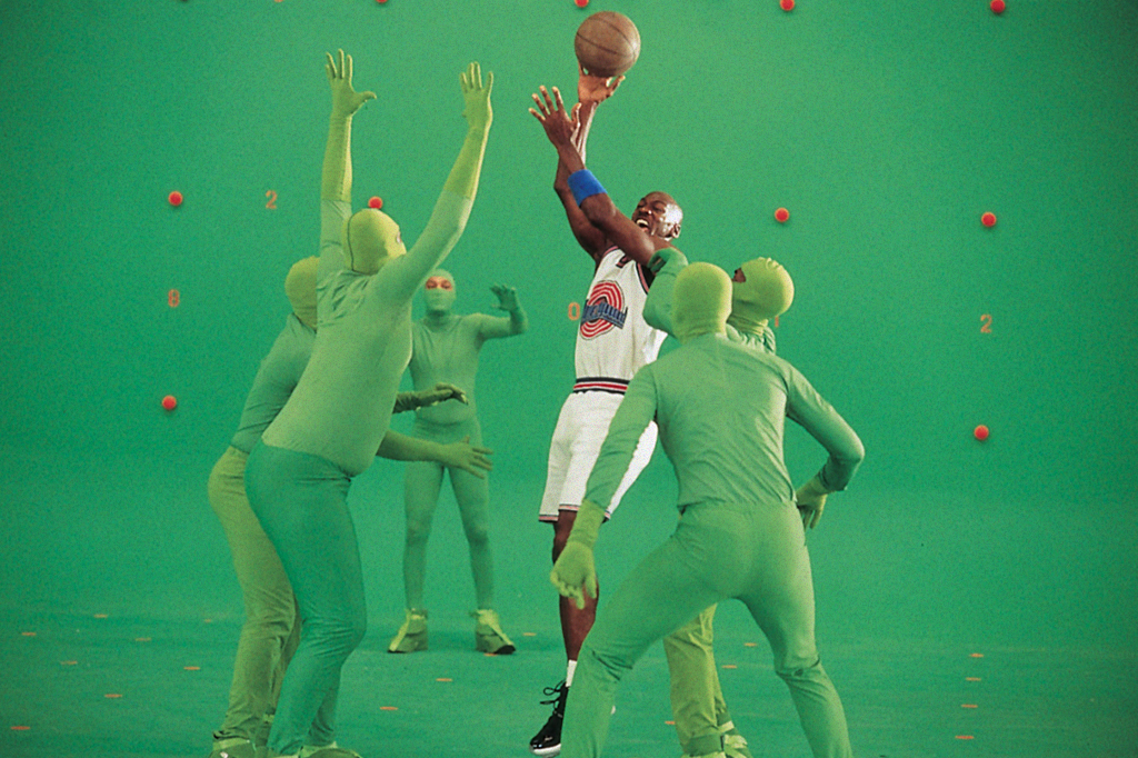 SI_429_Playlist_ABRE_04 Foto de Michael Jordan filmando Space Jam ao lado de pessoas usando roupas verdes.