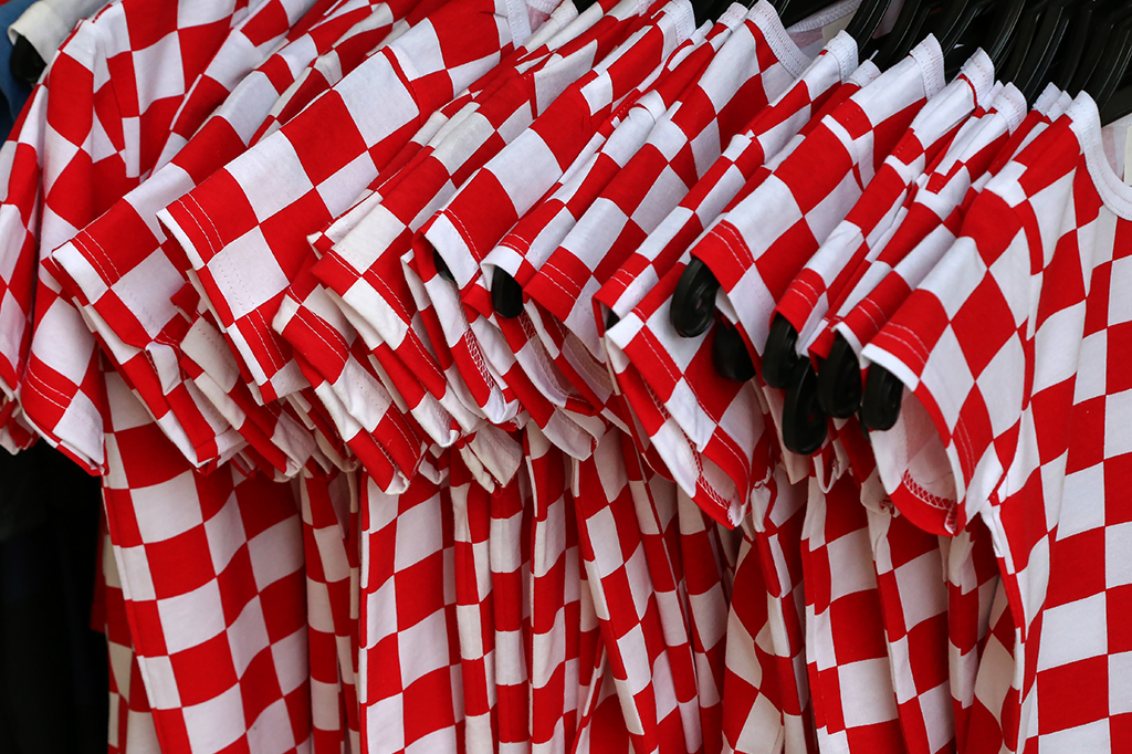 SI_croacia_site Cabides com camisetas estampadas de xadrez vermelho e branco.