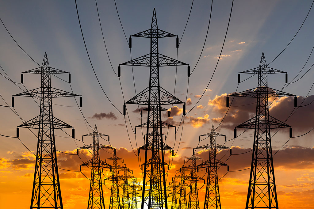 Foto de torres elétricas de alta voltagem ao por do sol.