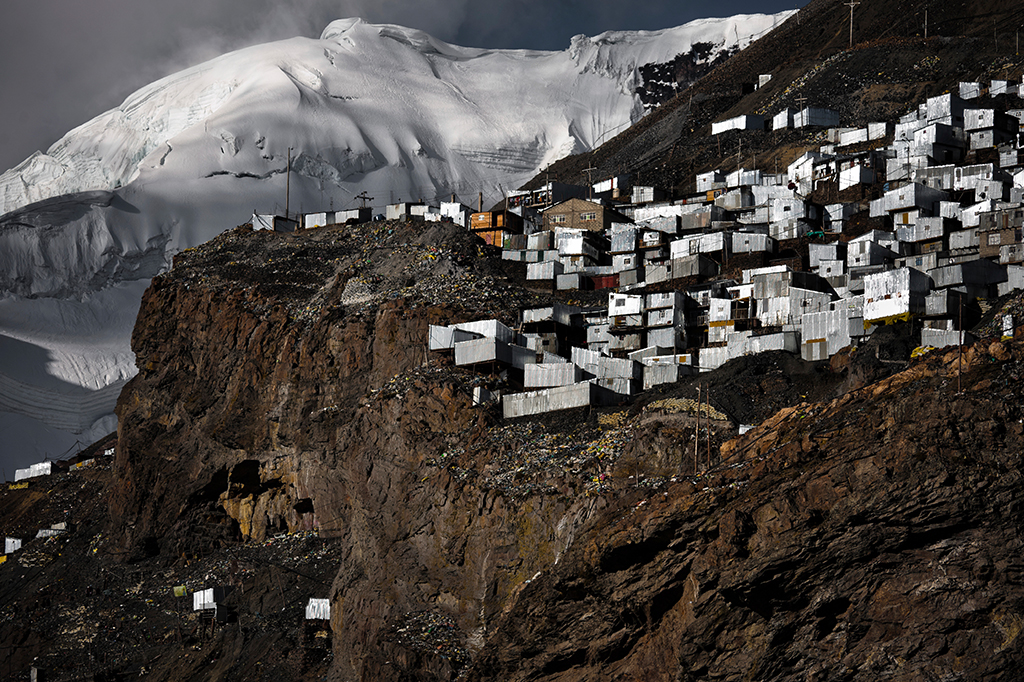 Barracos de metal corrugado, casas de garimpeiros, vistos na encosta de uma montanha íngreme sob uma geleira em La Rinconada, Peru.