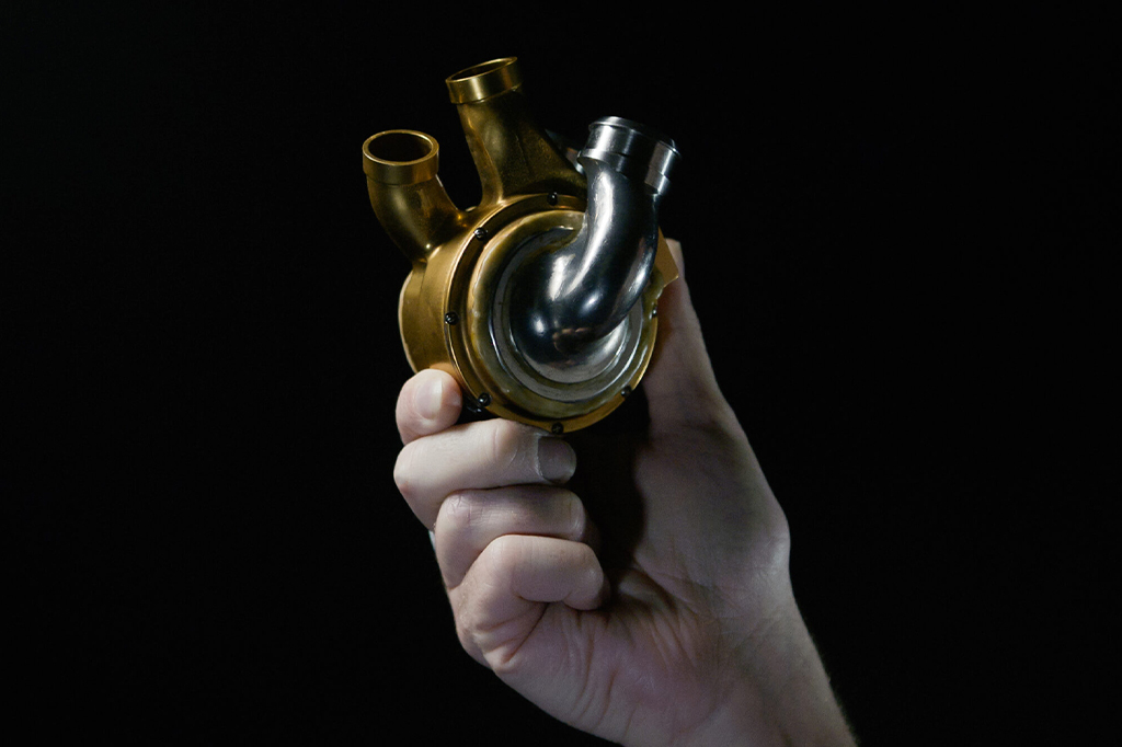 Fotografia do coração de metal sendo segurada por uma mão.