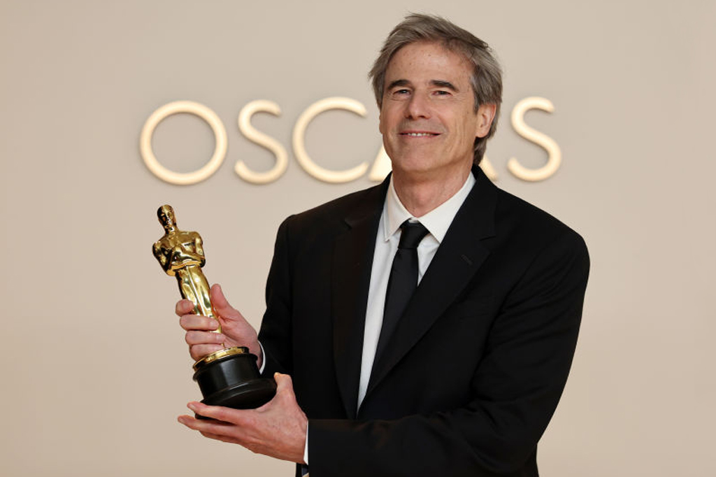 SI_473_Oráculo_Conexões_5 Image de um homem sorridente segurando a estatueta do Oscar.
