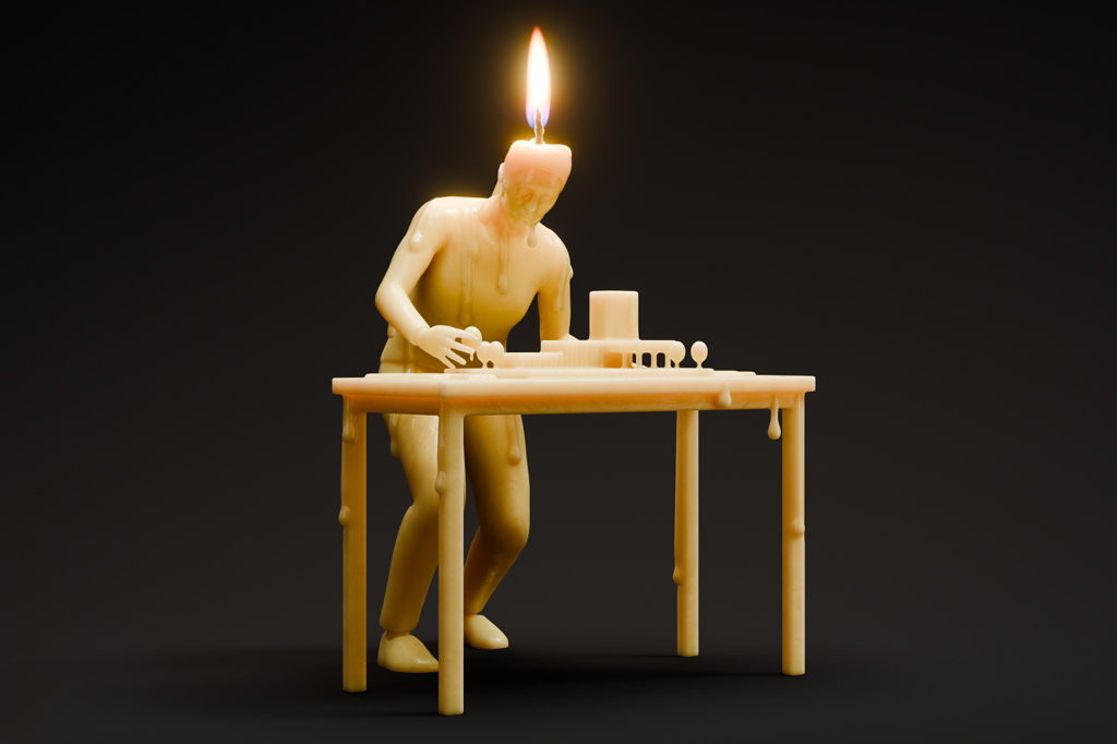 Imagem, em fundo preto, de um rapaz feito de cera com um pavio acesso acima da cabe&ccedil;a. Ele est&aacute; montando uma maquete de arquitetura em cima de uma mesa.