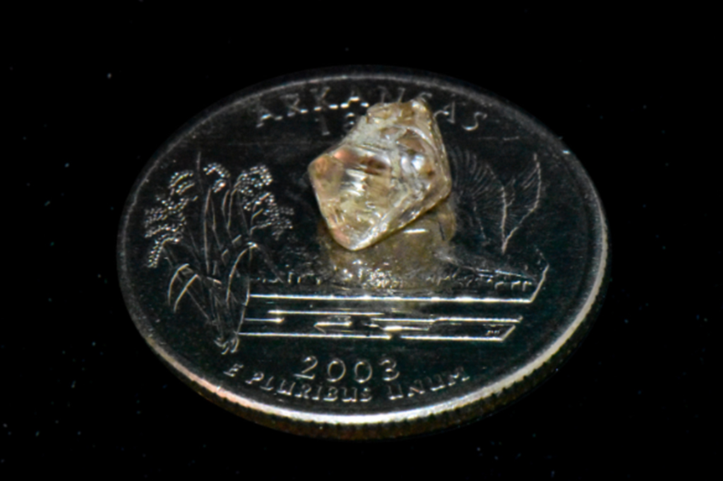 Fotografia do diamante sobre uma moeda.