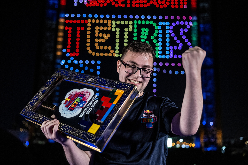 Fotografia de divulga&ccedil;&atilde;o da parceria da Red Bull com o jogo Tetris. Imagem de um homem segurando o trofeu do tetris.