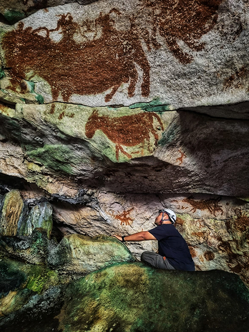 Fotografia do Dr. Shinatria Adhityatama trabalhando na caverna.